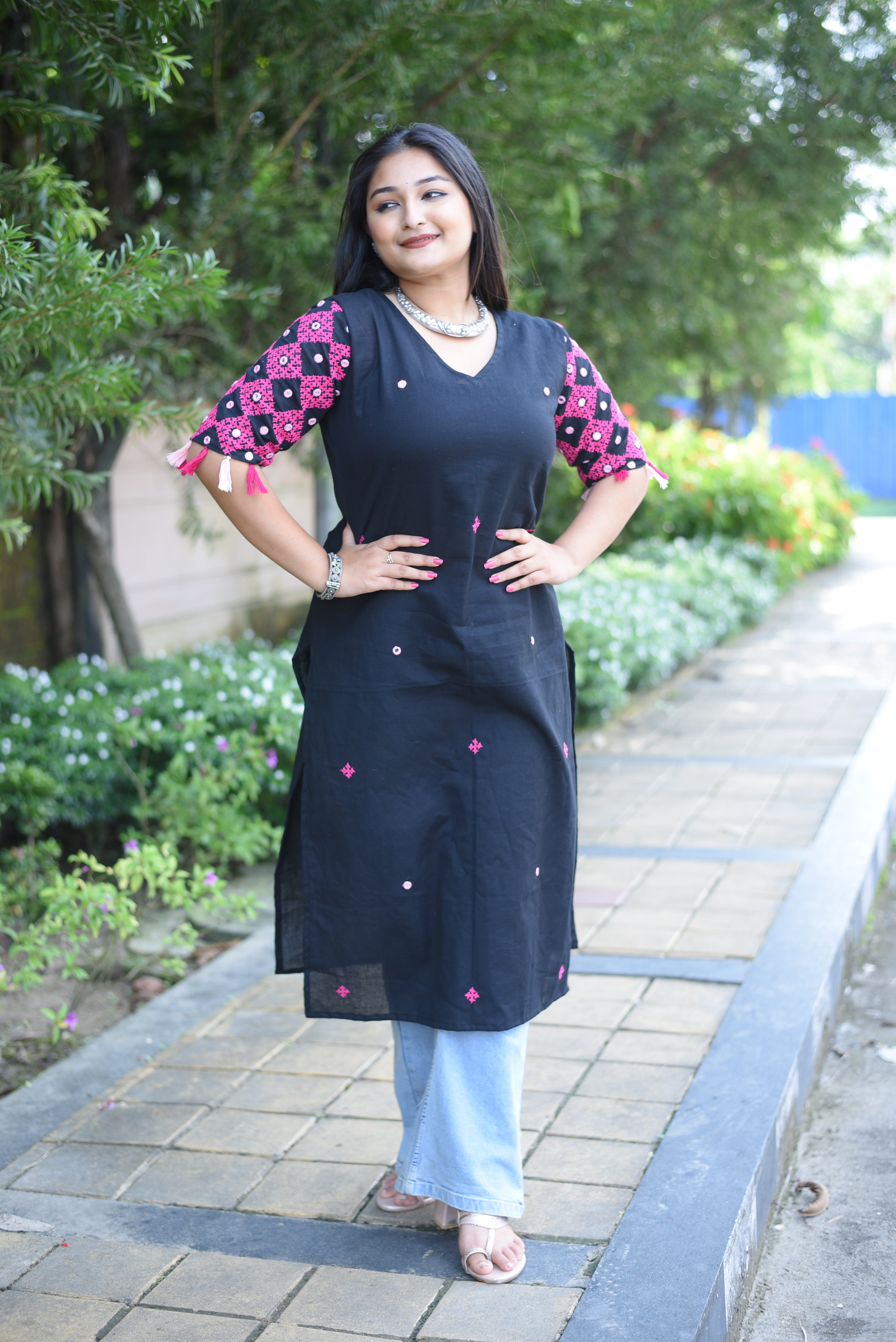 Woman wearing a black dress with pink polka dots outdoors